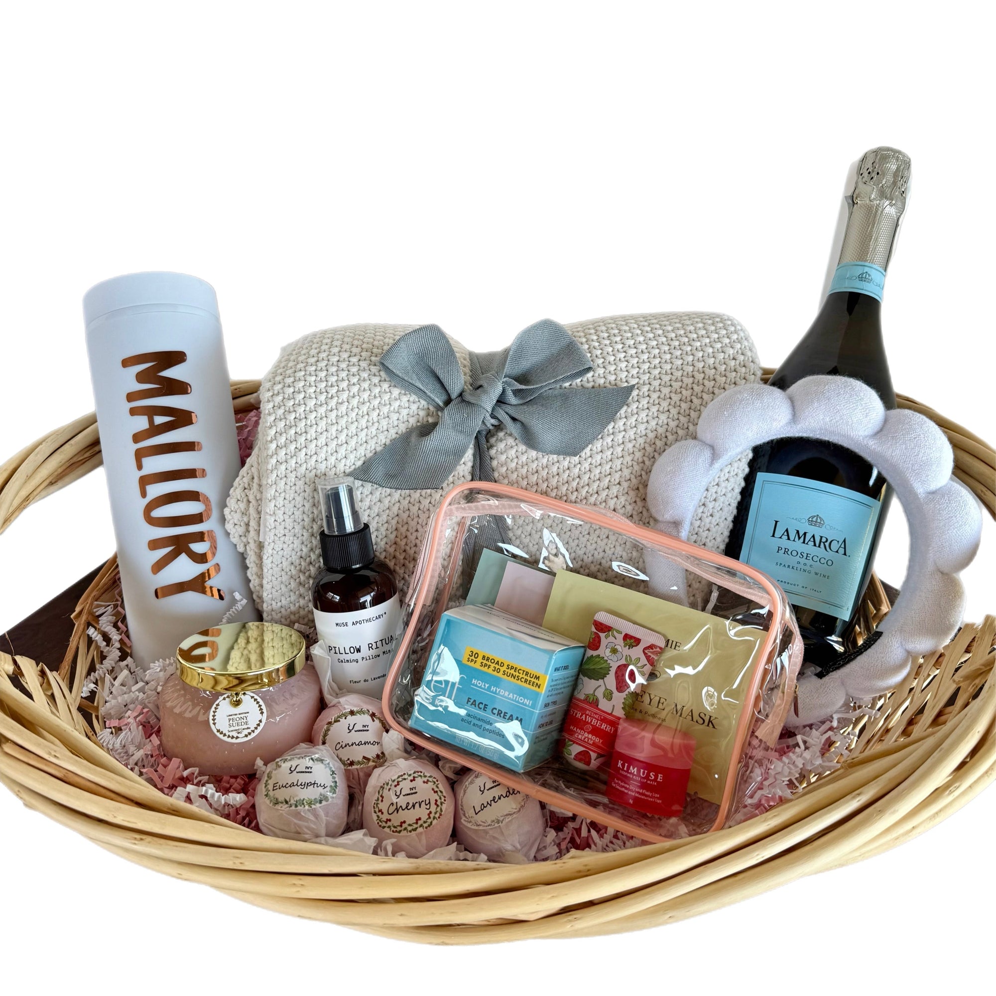 Gift basket with a bottle of wine, blanket, and various items on a white background